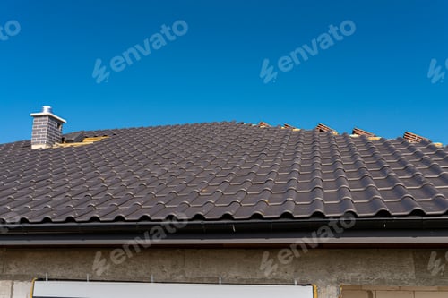 Preview: The roof of a single-family house covered with a new ceramic tile in anthracite, against the blue sk