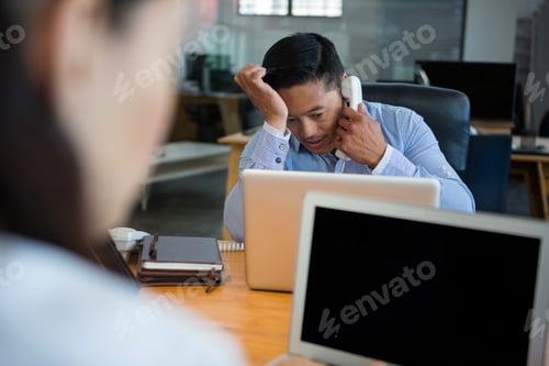 Preview: Frustrated business executive talking on telephone