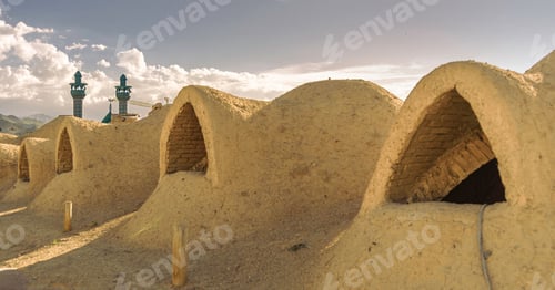 Preview: Traditional mud brick structures and blue minarets.