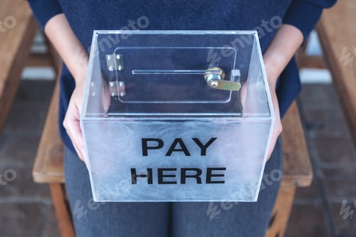 Preview: A woman holding a plastic payment box