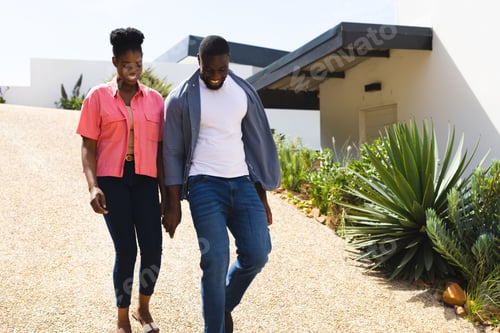 Aperçu: Couple walking outdoors on sunny day, enjoying time together and smiling