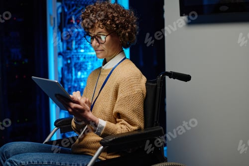 Preview: Female network engineer in wheelchair using tablet pc