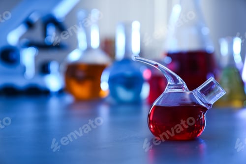 Preview: Retort flask on table against blurred background, space for text. Chemistry glassware