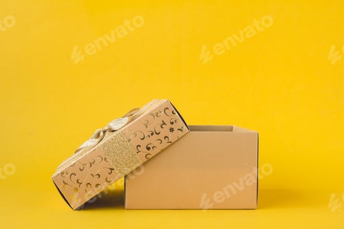Preview: Open golden gift box on a yellow background.