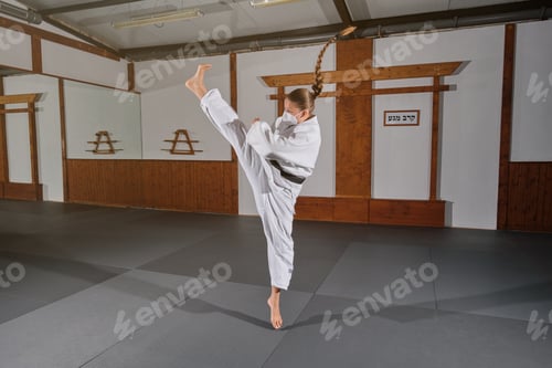 Preview: Woman wearing a mask with a white kimono kicking in the air