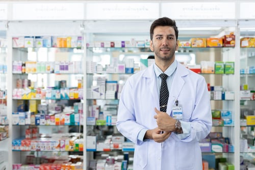 Preview: Portrait male charming smiling pharmacist. man professional medication in drugstore.