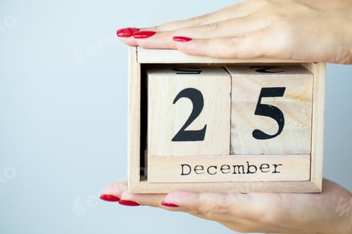 Preview: Woman in hand holds Christmas decorations on light background