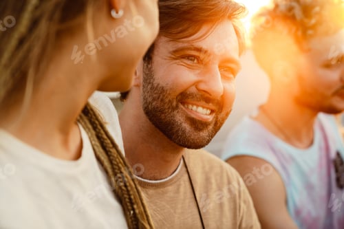 Preview: White couple hugging and White couple hugging and smiling during picnic with their friends