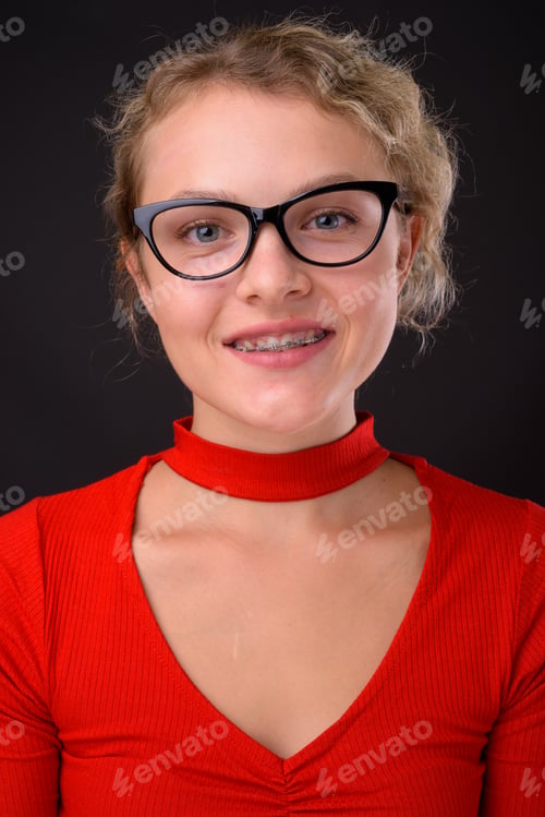 Preview: Young beautiful woman with blond curly hair against gray backgro