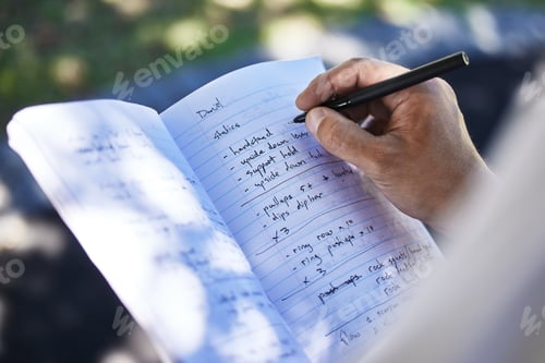 Preview: Exercise plan loading. Shot of a unrecognizable man writing in his notebook outside in the park.