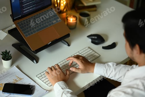 Preview: Software developers programming on desktop computer at night