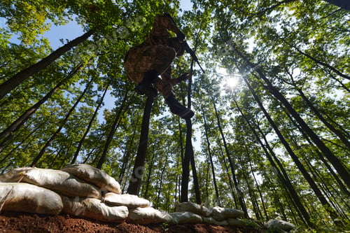 Preview: An elite soldier adeptly clears military barriers in the perilous wooded terrain, showcasing