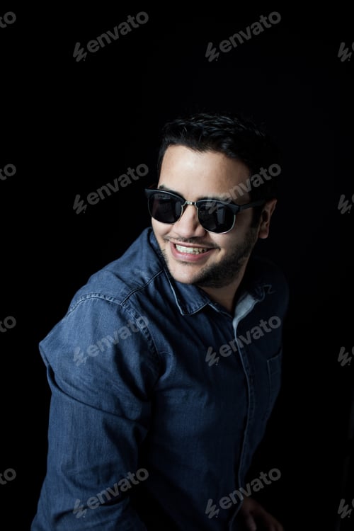 Preview: Man Looking back wearing sunglasses and denim shirt looking back with a smile