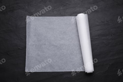 Preview: Roll of baking paper on black table, top view