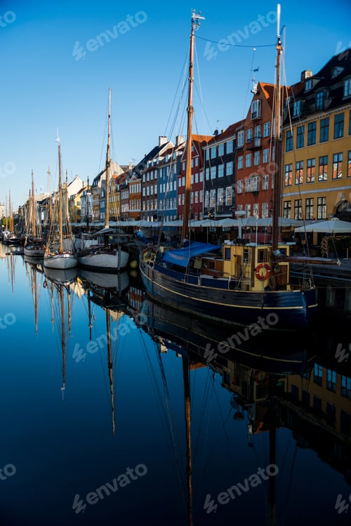 Preview: COPENHAGEN, DENMARK - 06 MAY, 2018: Nyhavn pier with color buildings and boats reflected in water,