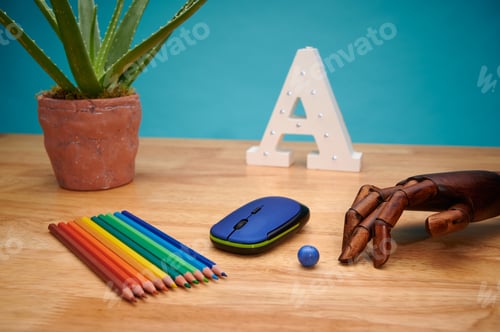 Preview: Computer mouse with multicolored pencils, articulated wooden hand, and aloe plant