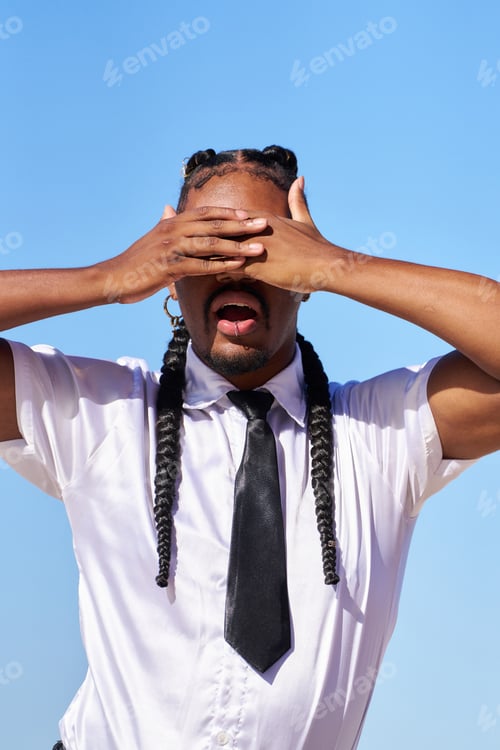 Preview: Androgynous businessperson covering eyes with hands and open mouth under blue sky