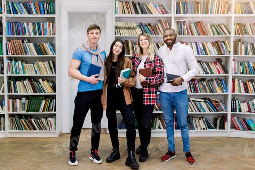 Preview: Group of four confident smiling multiethnical students, girls and boys in casual wear, posing in the