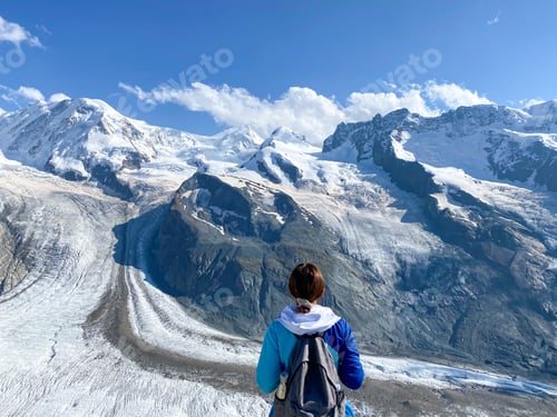Vista previa: A hiker enjoying the views at glacier and snow covered mountain tops in the Swiss Alps