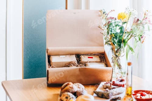 Preview: Gourmet gift box with artisanal food and flowers on a wooden table
