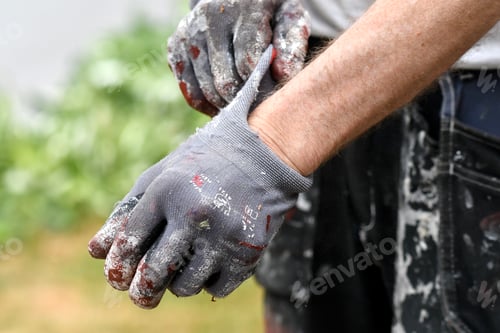 Preview: Closeup macro of a man putting on gloves for painting