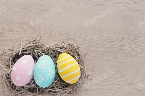 Preview: Pastel and colorful easter eggs on nest with wooden background and copy space, happy easter