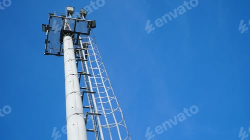 Preview: High lighting mast against the blue sky. View from below. Full height.