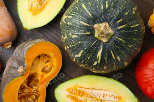 Preview: Many fresh pumpkins and melon on wooden table, flat lay. Gourd family