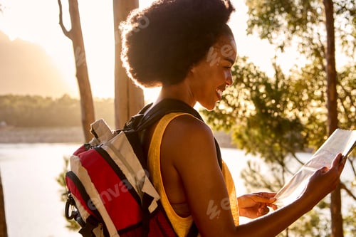 Preview: Woman With Map And Backpack On Vacation Hiking By Lake At Sunset