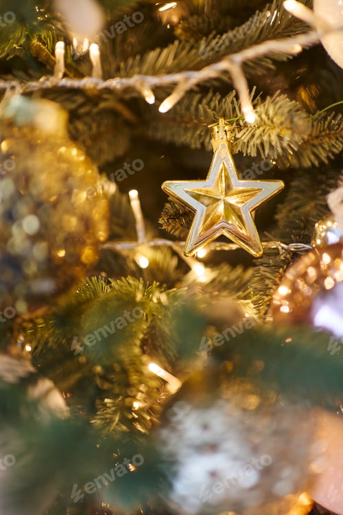 Preview: close-up of a New Year's toy golden star and golden balls. beautiful New Year tree with golden