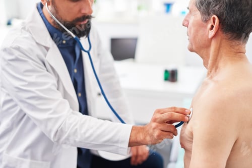 Preview: Side view of doctor examining senior man