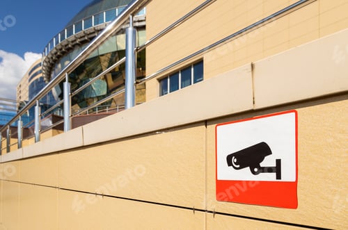 Preview: Close-up of sign warning about video observation area on beige building wall