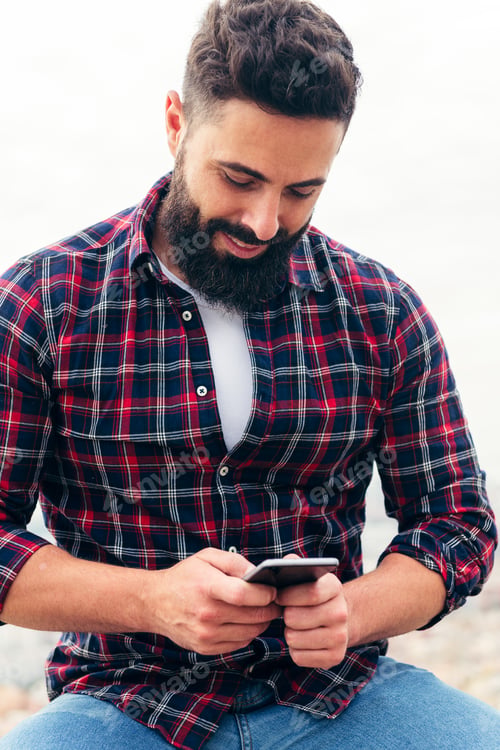 Preview: bearded man typing a text message on his phone