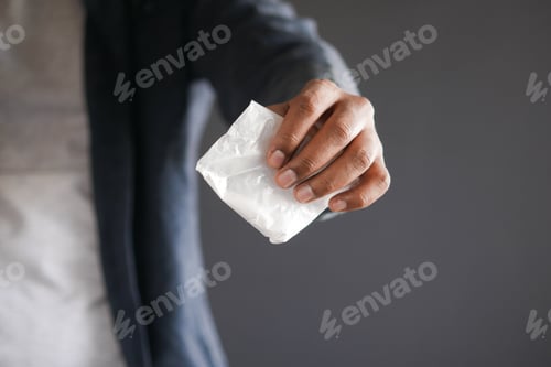 Vista previa: drug addiction concept with hand holding heroine packet on black backgrund