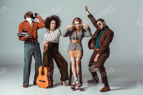 Preview: multicultural retro styled friends having fun with guitar and vintage electronics on grey
