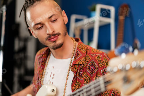 Preview: Young man guitar player sitting and performing on a couch