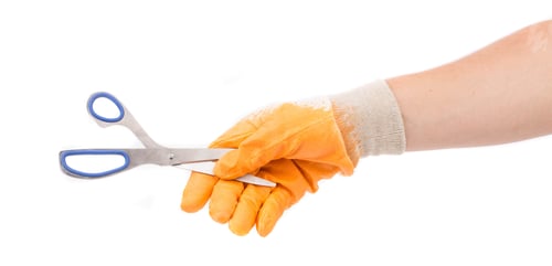 Preview: Hand in yellow glove holding scissors.