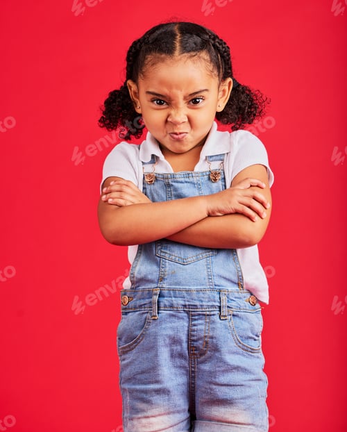 Preview: Child, arms crossed or angry portrait on isolated red background for tantrum face, behavior problem
