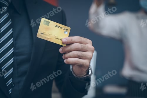 Preview: Portrait of businessman showing a credit card in coffee shop.