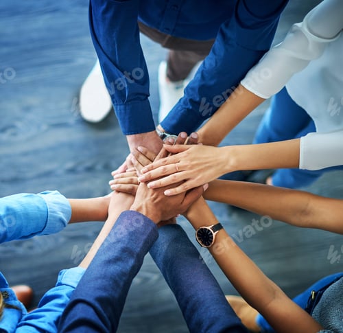 Preview: High angle shot of a group unrecognizable businesspeople joining their hands together in unity