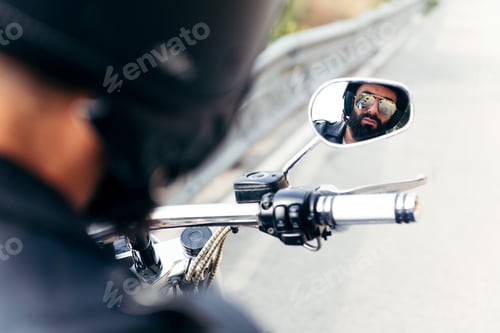 Preview: biker reflected in the mirror of his motorcycle