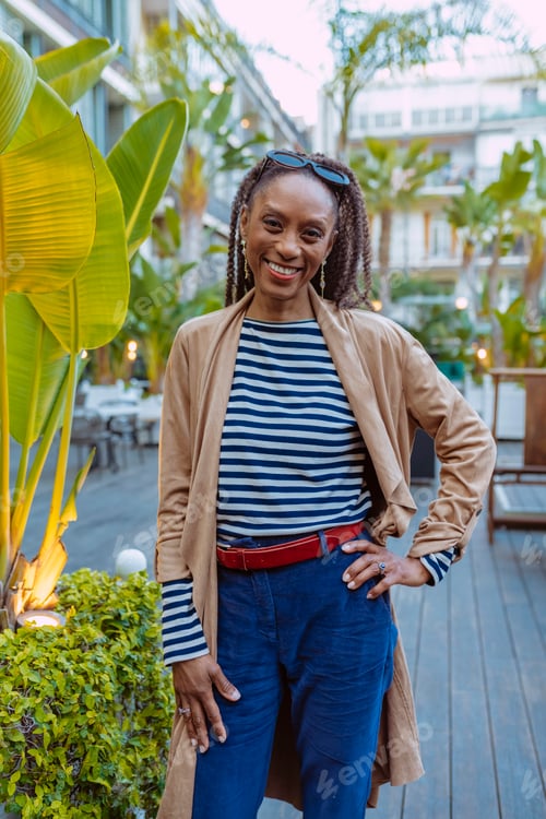 Preview: Stylish mature black woman smiling in a tropical hotel