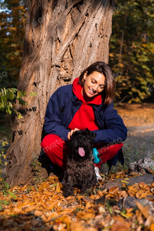 Preview: Early morning. Happy woman sleepy eyes with dog in park, autumn orange yellow colors.