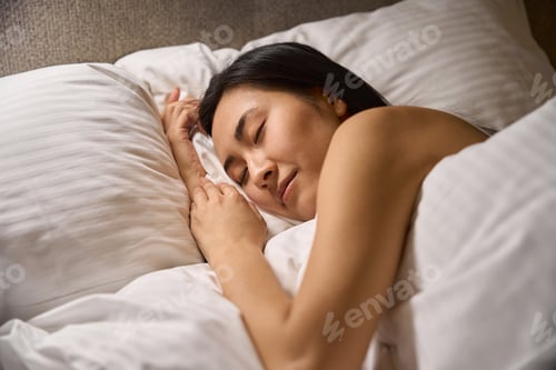 Preview: Beautiful Asian woman resting lying in cozy bed on orthopedic pillows