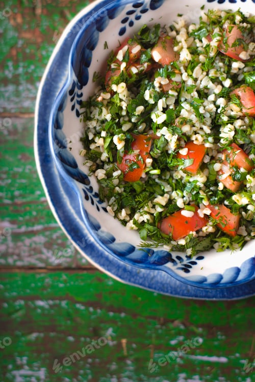 Preview: Tabouli middle eastern salad at glass bowl over floral napkin