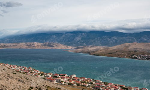 Preview: Amazing landscape with mountains behind bay. Sea, clouds, town. Pag, Croatia.