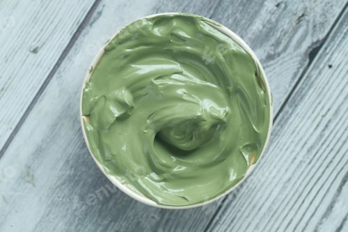Preview: green clay mask in container on wooden background