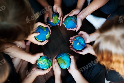 Preview: Group of diverse kids hands holding cupping globe balls together