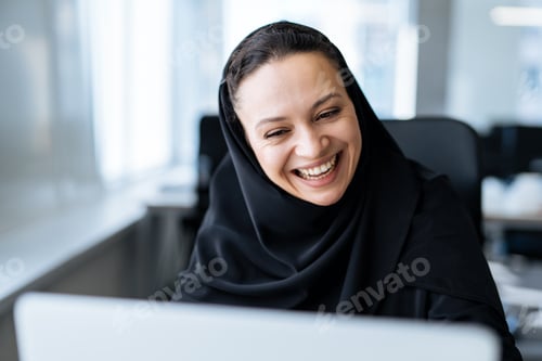 Preview: Beautiful arabian woman with abaya dress working in the office