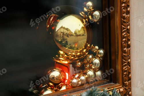 Preview: Stylish christmas spruce branches and gold baubles decoration on window. Xmas festive street decor